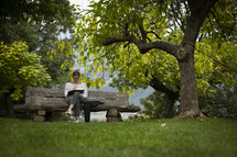 woman studying on a bench in a park