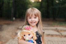 smiling girl holding a doll 