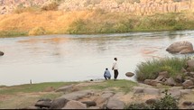 men skipping rocks across a river 