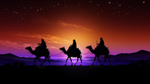 Three wisemen journey to Bethlehem at sunset. 