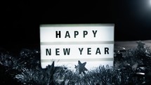 Happy New Year message with flashing light, black and white