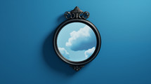 Round mirror on a blue wall with clouds. Self reflection and future concept.