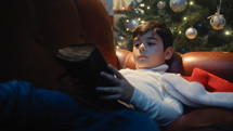 Child reading old Christmas book relaxing on the Sofa 
