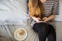 girl texting sitting on her bed 