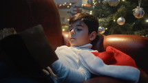 Child reading old Christmas book relaxing on the Sofa 