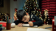 Kid writing letter to Santa Clause On Table
