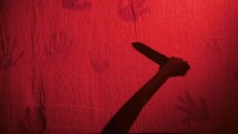Killer With Knife Behind Red Curtain