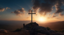 A man standing by a cross looking off in the distance at sunset. 