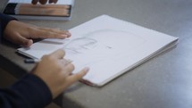 a person sketching a face 