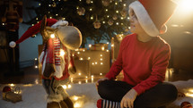 Child putting lights on a Christmas puppet