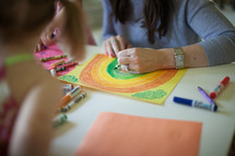 children coloring with mom at a table 