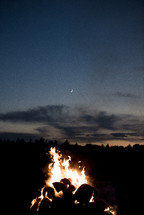 crescent moon over a campfire 