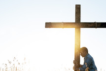 a man standing next to a cross praying 