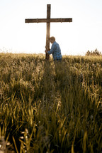 a man standing next to a field praying 