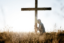 a man standing next to a cross praying 