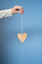 woman holding a heart on a string 