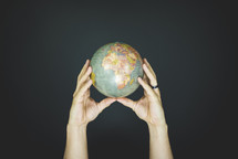 hands holding up a globe 