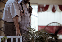 elderly men holding microphones 