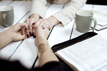 friends having coffee and praying together 