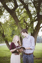 a couple reading a Bible together outdoors 