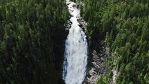 aerial view over a waterfall and forest 