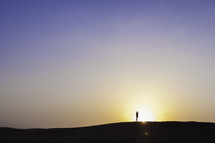 silhouette on a man in the desert at sunset