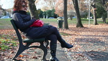 a woman sitting on a park bench 