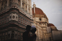bride and groom kissing in front of a palace