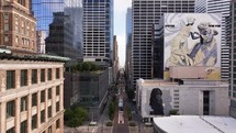 Aerial view going down Main Street in Houston, Texas with tall buildings, traffic and city murals.