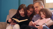 grandparents reading a Bible to grandkids 