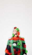 A man covered in Christmas bows and ribbon