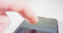Macro shot of finger scrolling through social network on a smartphone