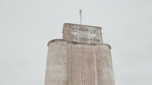 Drone shot of grain elevator in a small rural town on a snowy winter day.