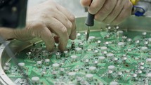 Close up of manual soldering of a large circuit board