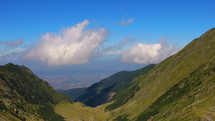 Panoramic view mountains and white clouds on blue sky. Touristic and travelling destination. Hand held 