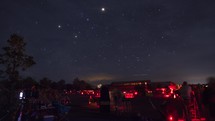 Timelapse of a large group of astronomers with telescopes and the stars above