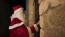 Santa Claus using a door knocker on Christmas night 