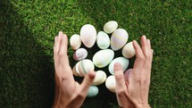 Hands Collecting colorful easter eggs 