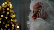 Santa Claus absorbed by his computer screen 