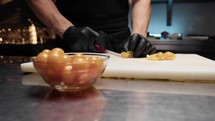 Professional chef cutting tomatoes with tiny knife