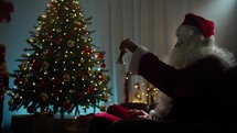Santa Ringing the bell under Christmas tree 