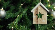 Decoration of a star form inside a house hanging from a Christmas tree 