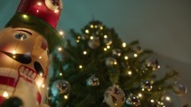 Nutcracker with Christmas tree and lights background 