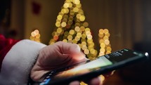 Santa Claus scrolling with smartphone on social media 