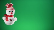 Tiny snowman decoration for Christmas with green background 