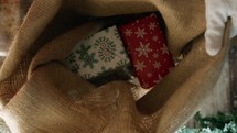 Santa Putting christmas presents in his bag 