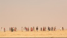 people walking through a desert 