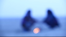 blurry silhouettes by a campfire 