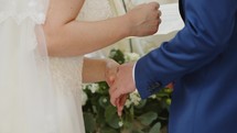 Bride and groom wear their wedding ring