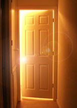 A white wooden door cracked opening to sunlight and light pouring in like a door to Heaven or doorway to the future. The unknown might be frightening but with Christ, He is our hope for the future to open doors that no man can close. 